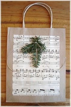 a paper bag with sheet music on it and a pine branch hanging from the front