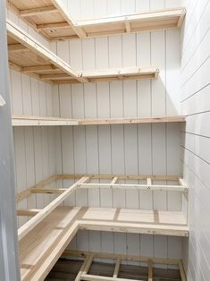 empty wooden shelves in a room with white walls and wood planks on the floor