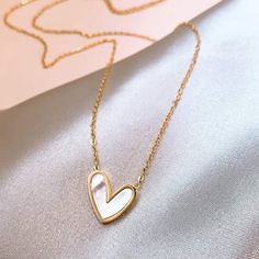 With a simple, yet bold feel this necklace brings, it is the perfect compliment to any outfit! Necklace Details: * 3/4" Gold / Mother of Pearl Heart Pendant * 18K gold / Stainless Steel Necklace Sizing: * 15" with 2" Extender (View Chart if Needed) Every piece of jewelry you order is delivered in an elegant organza bag. For that extra special touch, consider our upgraded Gift Package Option during checkout making your gift-giving experience truly memorable. Heart Necklace Aesthetic, Pearl Heart Necklace, Feminine Necklace, Mother Of Pearl Pendant, Necklace For Mom, Jewelry Set Design, Fancy Jewellery Designs, 18k Gold Necklace, Pearl Heart