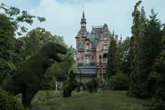 the topiary sculptures are made to look like animals in front of an old building