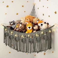 stuffed animals are sitting in a hammock with lights strung from the ceiling and stars on the wall