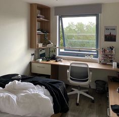 a bedroom with a bed, desk and window