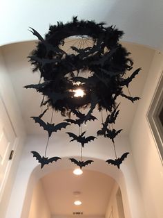 bats are hanging from the ceiling in an empty hallway with light bulbs on either side