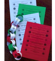 three different types of paper on top of each other with red and green ribbons attached to them