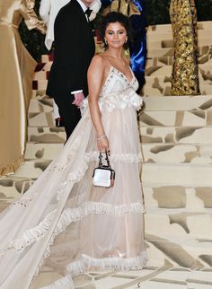 a woman in a white dress is walking down the aisle