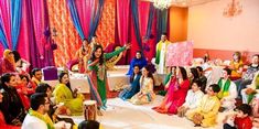 a group of people sitting around each other in front of colorful drapes and curtains