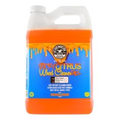 a gallon of orange liquid sitting on top of a white table