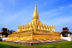 the large golden building has many spires on it's sides and is surrounded by green grass