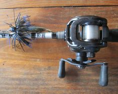 a spinning fishing rod and reel on a wooden table with a fish lure attached to it