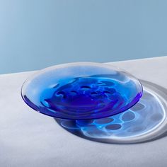 a blue glass plate sitting on top of a white table