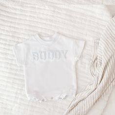 "Celebrate your sweetie with this piece featuring a white embroidered lettered text on a white colored romper. This sweet piece is the perfect romper for baby. The design is made on a 100% cotton fabric, light sweatshirt material. It is cozy soft and perfect for staying cuddly. This romper is oversized in style in a baby sweatshirt bubble romper design. Select the words you would like in the \"personalization\" section. Your word of choice must be under 7 in order to fit across the chest. Please note: the letters themselves are pre-embroidered and are transferred to the product using heat :) This product is handprinted using nontoxic, water-based inks. Gentle cycle on cold inside out, lay flat to dry or gentle cycle for best results. Do not iron over design. Product will come packaged with Casual Personalized White Onesie, White Personalized Short Sleeve Onesie, Casual White Personalized Onesie, Basic White Short Sleeve Onesie, White Short Sleeve Cotton Bodysuit, White Letter-printed Short Sleeve Bodysuit, White Short Sleeve Bodysuit With Letter Print, Cotton Baptism Onesie With Short Sleeves, White Short Sleeve Onesie For Baptism