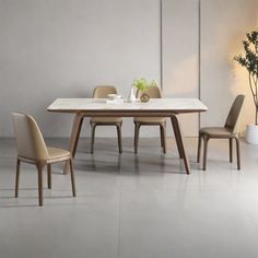 a dining table with four chairs and a vase on the side, in front of a white wall