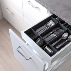 an open drawer with utensils and silverware in it