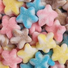 small star shaped candies are scattered on top of each other in pastel colors