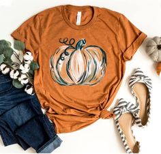 "Fall Pumpkin Shirt, Cute Fall Shirt, Thanksgiving Tshirt, Graphic Tee for women, Pumpkin Spice Tee, Teacher Fall Shirt, Autumn Shirt, Fall T ⭐Please Check All Photos For Details.   🐞Choose Your T-Shirt Size From The Drop-Down Lists Next To The item Picture   ⭐Choose Of Your T-Shirt Color From The 2nd Picture   🐞Use \"Add message to Seller\" link On The Checkout Page To Send me the Following important Details For Your Order's Customization.   ⭐Shipping Time Varies by location (we are located in Sugar Land, Texas) please consider that our turn around time is 1 to 3 business days.     ⭐Which brand do you use for t-shirts? We use Gildan Soft Style, Bella Canvas Unisex, Rustic United, Outlash, Tees Factory, Hanes, Comfort Color District and Next Level when we have a shortage of stocks for ce Teal Pumpkin, Cute Fall Shirt, Pumpkin Spice Shirt, Fall Shirts Women, Watercolor Pumpkins, Autumn T Shirts, Pumpkin Colors, Pumpkin Theme, Pumpkin Shirt