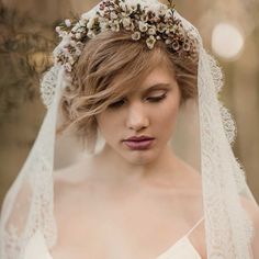 a woman wearing a veil with flowers on it