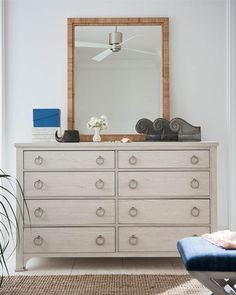 a bedroom with a dresser and mirror in it