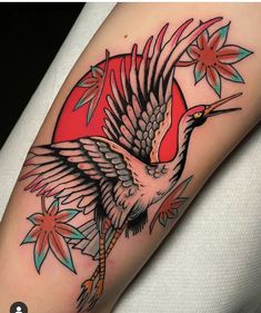 a bird is flying through the air with flowers on it's back leg and arm