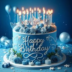 a blue birthday cake with lit candles on it's top and decorations around it