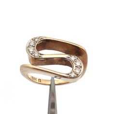 Designer 14K Yellow Gold Round Diamonds Modernist Abstract Swirl Statement Ring  Ring size: 5.75  Band width: 2 mm Top of ring measures: 3/4" x 1/2" Height: 3/16" Weight: 6.4 tgw 8 Round Diamonds measure approximately 1.3 mm x 2 mm Marked: Makers Mark * 14K Condition: As pictured. G4147