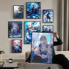 a woman sitting on a couch holding up a poster with anime artwork hanging above her