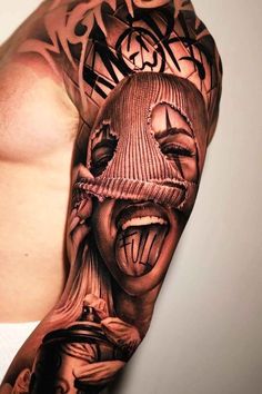 a man's arm with a creepy face tattooed on the upper half of his arm