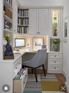 a home office with white cabinets and drawers