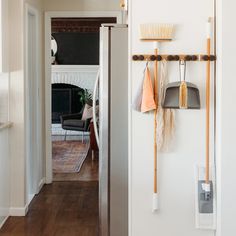 there are two brooms hanging on the wall next to each other in this hallway