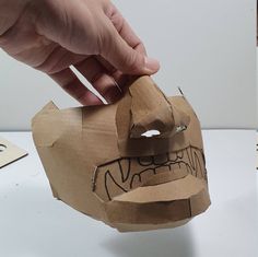 someone is making a paper mask out of cardboard