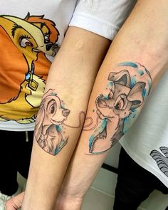 two people with matching tattoos on their arms, one has a dog and the other has a cat