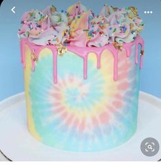 a tie dye cake with sprinkles and rainbow icing