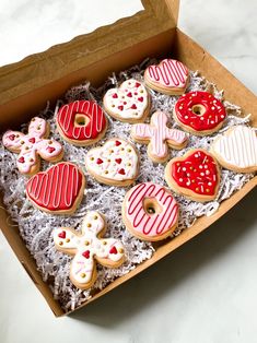 a box filled with lots of different shaped and decorated cookies on top of a table