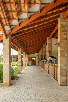 the walkway is lined with wooden posts and brick pillars, leading to an outdoor kitchen