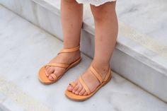 "Buy your daughter's first pair of sandals as she begins to take her first steps. Perfect for summer these flat kids' sandals feature a beautiful design without buckle closure. They are handmade of genuine leather in natural color that fits with all styles of outfits. Natural leather offers that crafted look, while the durable rubber sole is lightweight and features flex grooves for maximum flexibility. Perfect infant sandals for baptism, baby shower gift, birthday gift... 👶For Girls 👶Genuine Open Toe Sandals For Spring Gift, Open Toe Sandals As A Spring Gift, Open Toe Sandals For Spring, Girls Sandals Kids, Girl Sandals, Leather Sandals Handmade, Shoes For Girls, Genuine Leather Sandals, Handmade Sandals