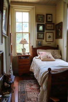 a bed sitting in a bedroom next to a window with pictures on the wall above it