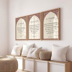 three framed pictures hang on the wall above a wooden bench with white cushions and pillows