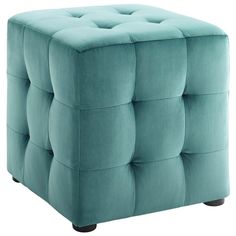 a blue ottoman that is sitting on top of a white floor and it's upholstered