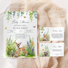 a baby shower with deer and flowers on it, next to two place cards for guests