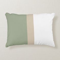 a green and white pillow with two horizontal stripes on the front, along with an off - white background