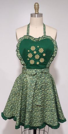 a dress on a mannequin with green and white flowers in the center,