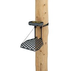 a bird feeder hanging from the side of a wooden pole with a wire attached to it