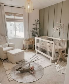 a baby's room with a white crib, chair and rug on the floor