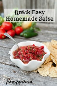 homemade salsa in a white bowl with tortilla chips on the side and tomatoes