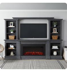 a living room with a fireplace, entertainment center and tv on it's stand