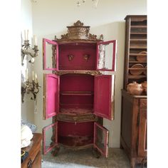 an old fashioned pink cabinet in the corner of a room