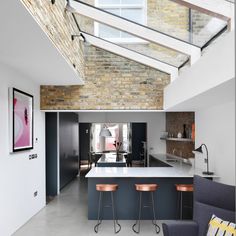 an open kitchen and living room with exposed ceilings