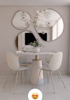 a white table with four chairs and a round mirror on the wall in front of it