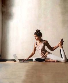 a woman is sitting on the floor with her laptop