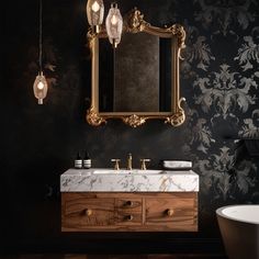 a bathroom with a sink, mirror and bathtub in black and gold wallpaper