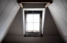 an open window in the corner of a room with white walls and wood trims